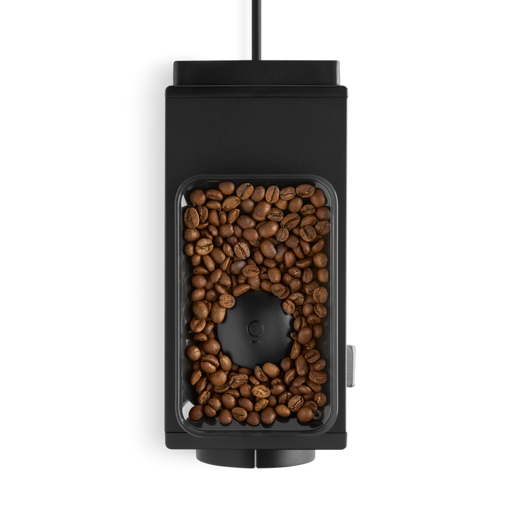 Fellow Ode coffee grinder in black top view with coffee