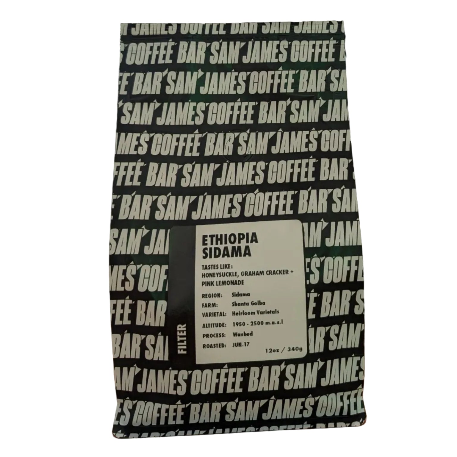 Black and white coffee bag with text on a wooden surface next to a potted plant