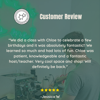A promotional graphic with a teal overlay reading 'Customer Review' and a customer testimonial quote from Jessica W, plus a five-star rating. The background shows a dimly lit workshop or studio scene with a person working at a table and equipment.