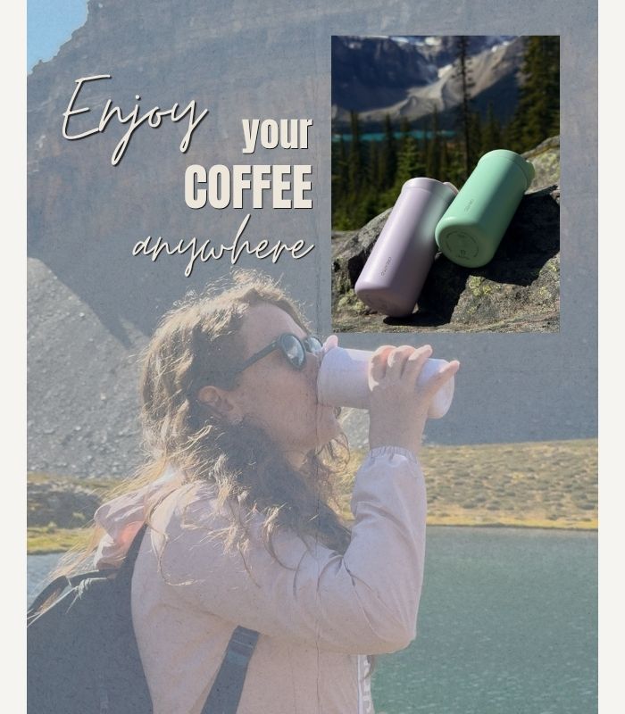 A woman outdoors by a lake and mountains drinks from a white reusable cup. An inset photo shows two reusable cups, one lavender and one mint green, resting on rocks with a mountain background in Helen lake , Alberta.